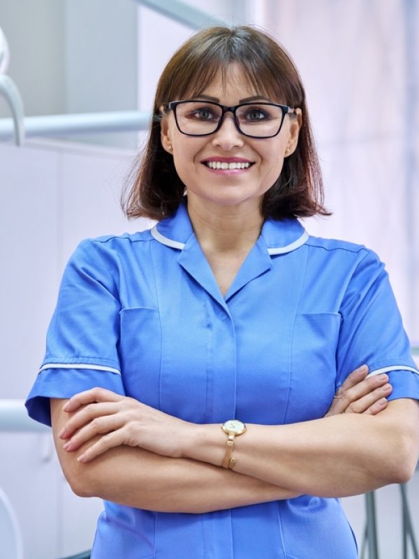 Portrait,Of,Smiling,Nurse,Looking,At,Camera,In,Dentistry.
